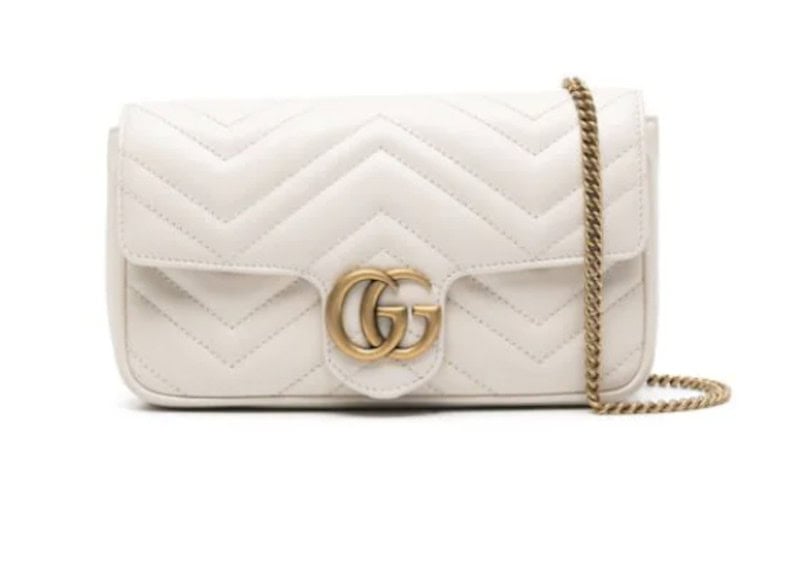A white Gucci crossbody purse with gold hardware. 