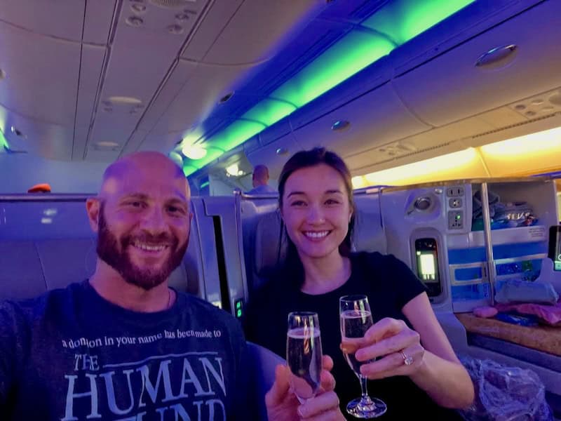 Couple enjoying champagne onboard an Emirates airbus A380 in business class seats. 